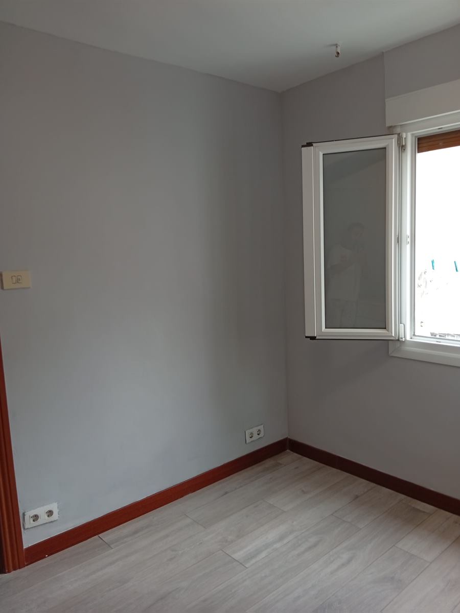 Habitación luminosa pintada en gris con ventana